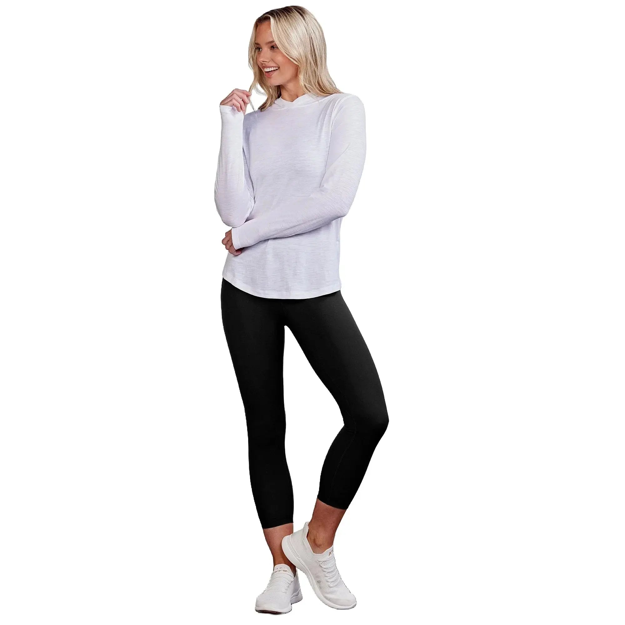 Model wearing a lightweight white long sleeve top with black leggings and white sneakers against a neutral background.