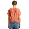 Back view of the Emily Surplice Short Sleeve Top showing a cinched hem and dolman sleeves, showing its construction and soft cotton fabric.
