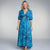 View of an elegant floral midi dress featuring a vibrant pattern, short sleeves, and a flowing silhouette