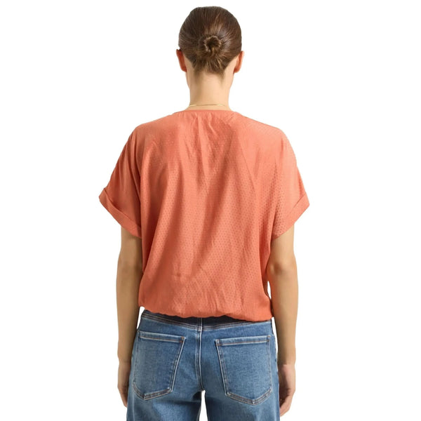 Back view of the Emily Surplice Short Sleeve Top showing a cinched hem and dolman sleeves, showing its construction and soft cotton fabric.