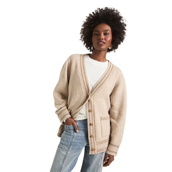 A model showcases a relaxed fit V neck cardigan in Heather Cream color, styled with high waisted jeans against a white background.
