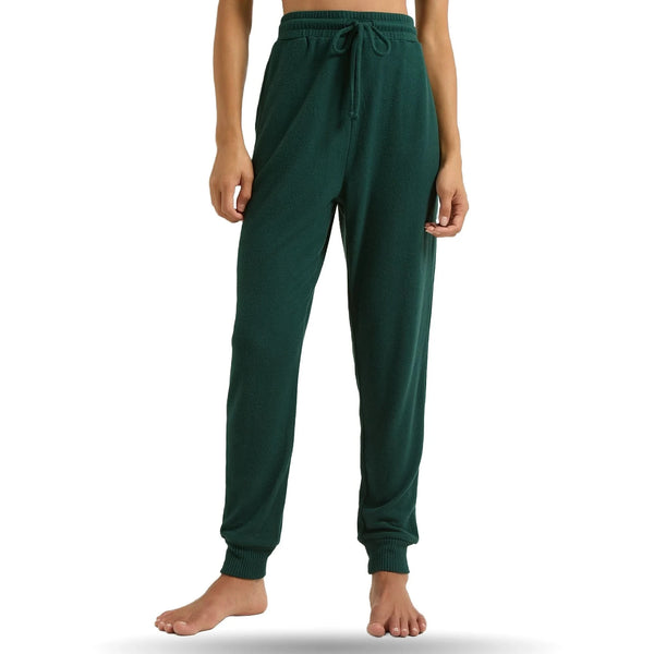Green joggers with elastic waistband and cuffs, worn cropped torso view