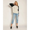 Model wearing Cream Black Emma Relaxed Raglan Long Sleeve Tee with light blue jeans and black clogs on white background.